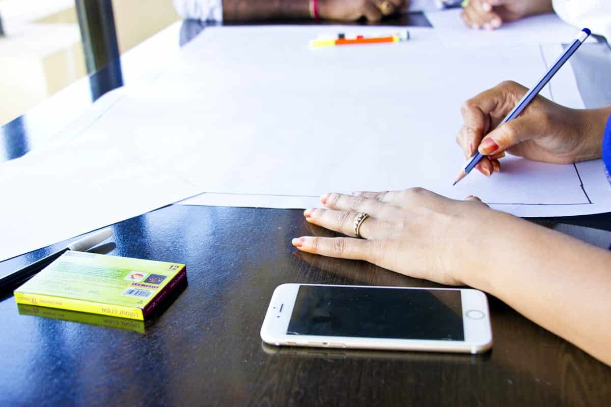 A photo of a mobile app designer starting a new sketch on a large piece of paper.