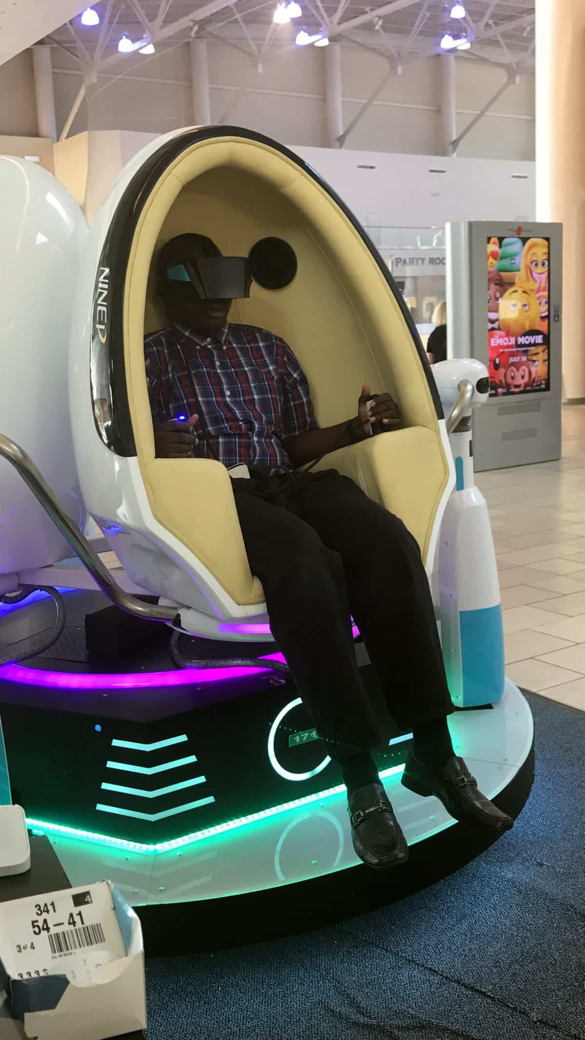 A photo of a man sitting in a VR simulator.