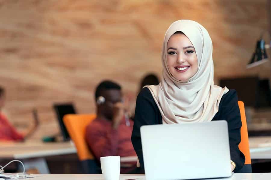 A photo of a female mobile app designer working on her laptop.