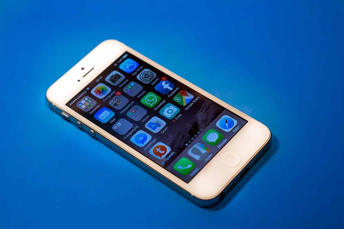A photo of a white iPhone displaying the home screen.