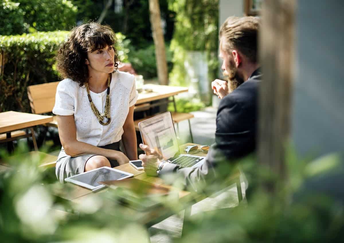 A man and woman conducting an interview on a patio.