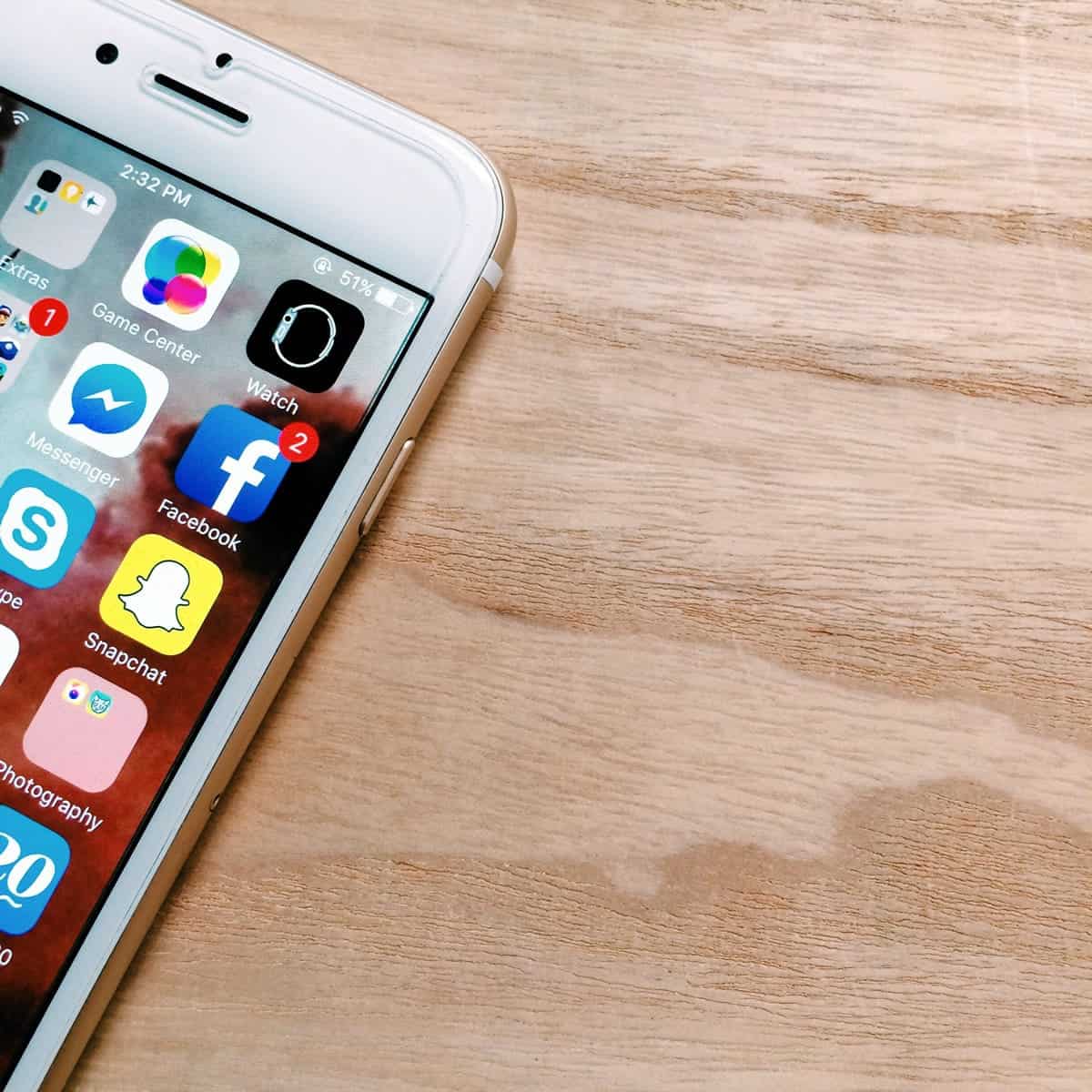 A photo of a white iPhone lying on a desk.