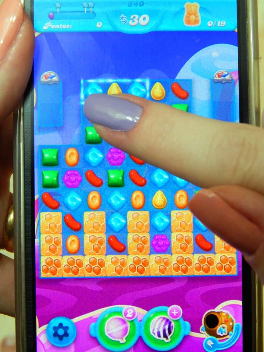 A photo of a person playing candy crush on their smartphone.