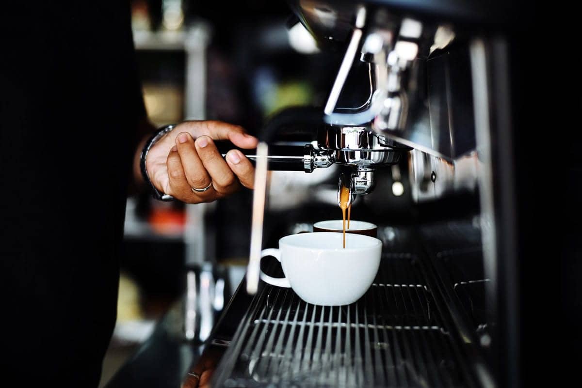 A barista makes a coffee drink.