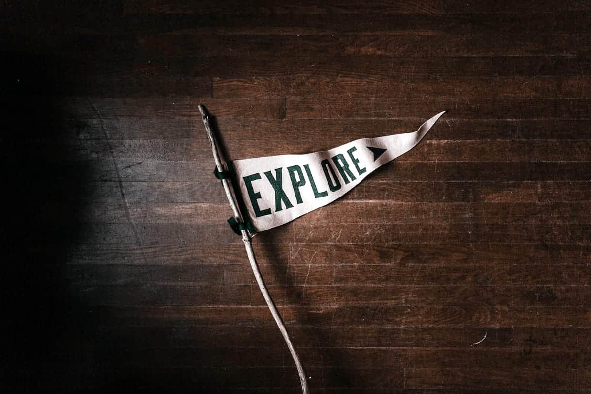 A flag that says “explore” on a wooden floor.