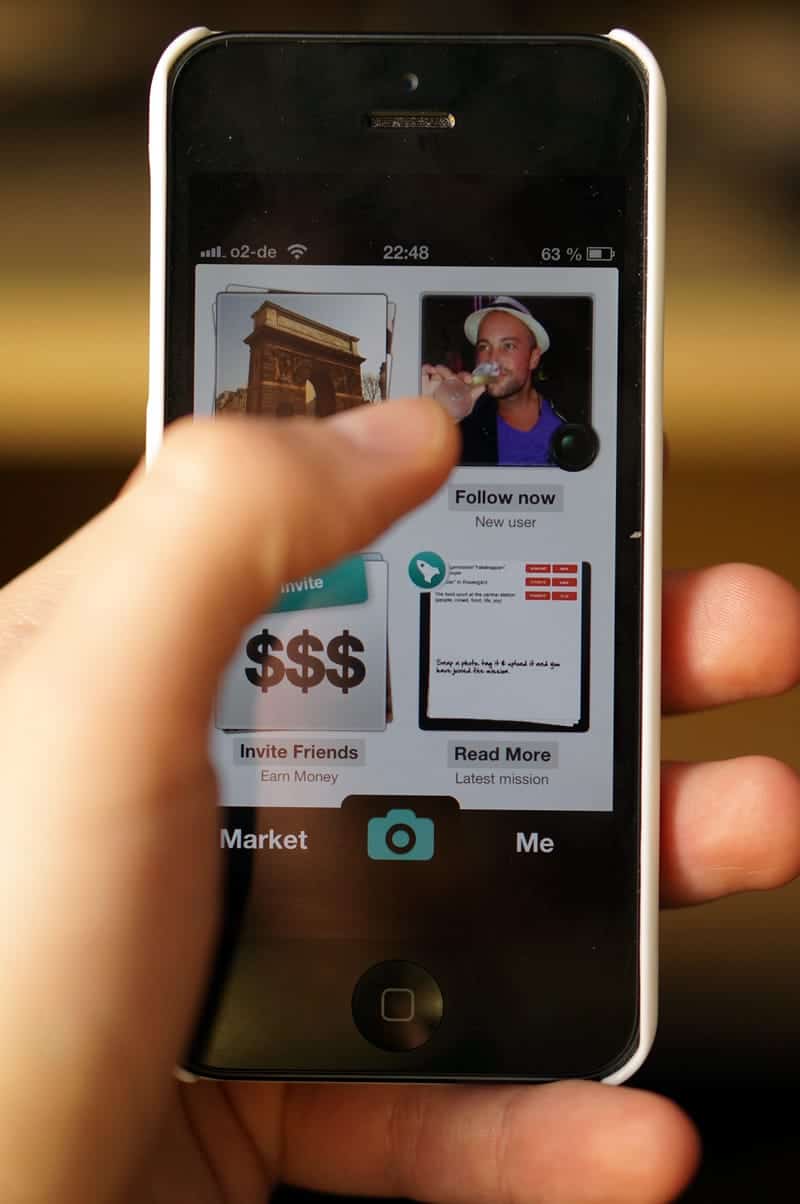 A close-up photo of a man’s hand holding an iPhone.