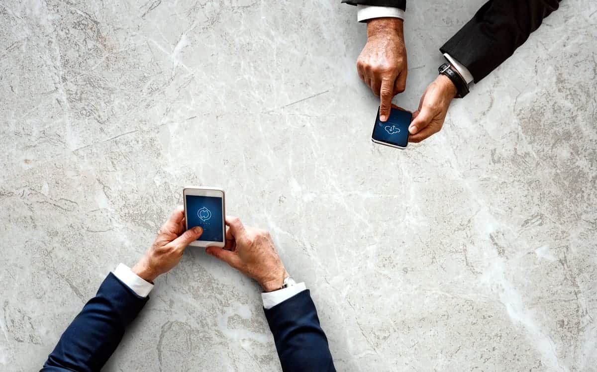 Men pointing at a smartphone mobile app prototype.