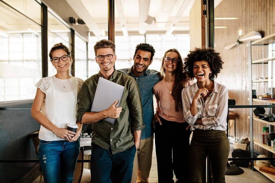 A photo of a design team, smiling at the camera at the conclusion of a design sprint.