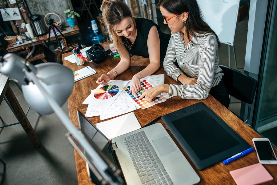 A photo of two members of a mobile app design team looking at color options.