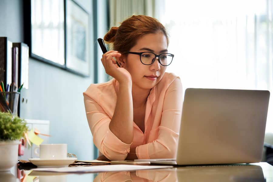 A photo of a young mobile app designer sitting at her desk, going over her latest design.