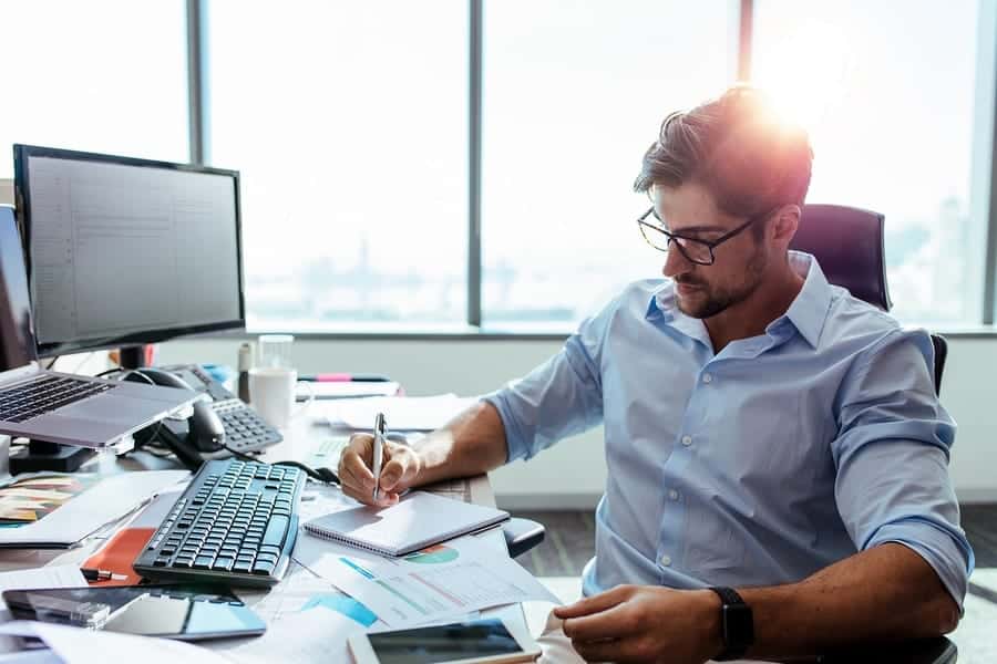 A photo of an entrepreneur sitting in his office, going over reports.