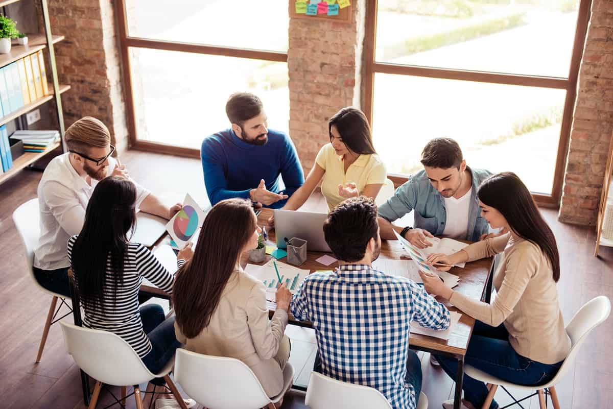 A photo of a mobile app development team meeting in a well-decorated, trendy conference room.