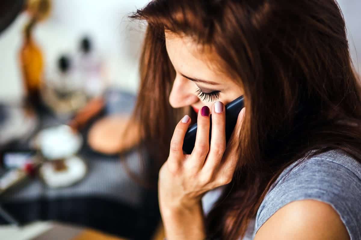 A woman talking on the phone to her coworkers.