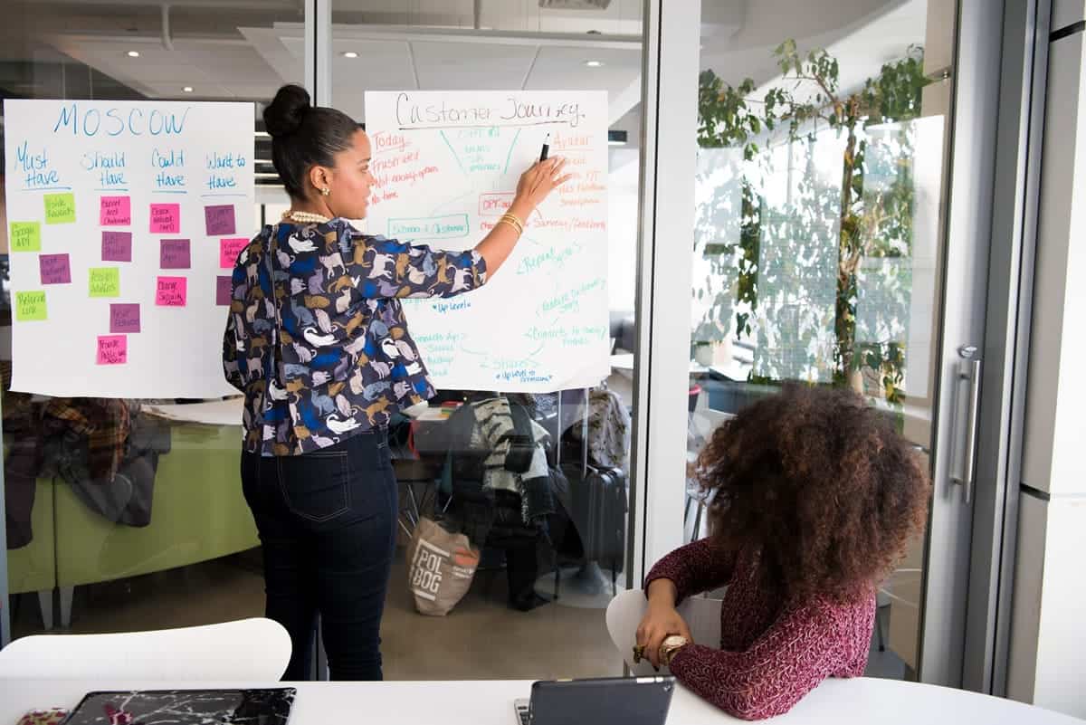 A woman brainstorming customer journey strategies during a meeting.