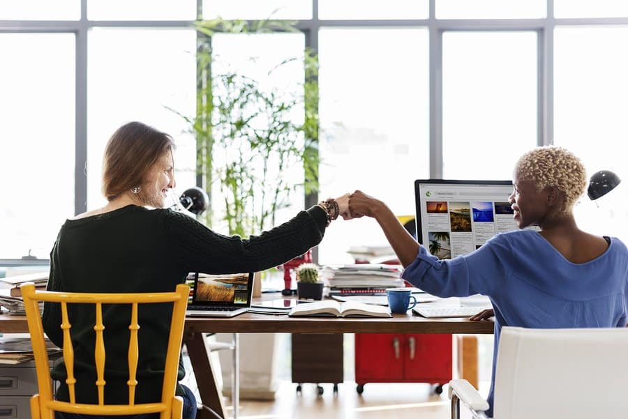 A photo of two teammates sharing a fist bump after accomplishing a task.