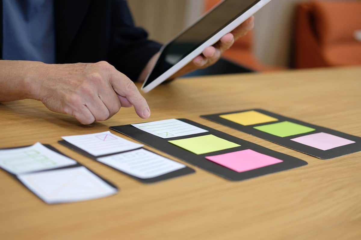 A photo of a mobile app designer using sticky notes to work on his mobile app layout.