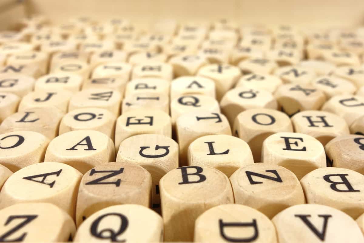 Many black letters on wooden cubes.