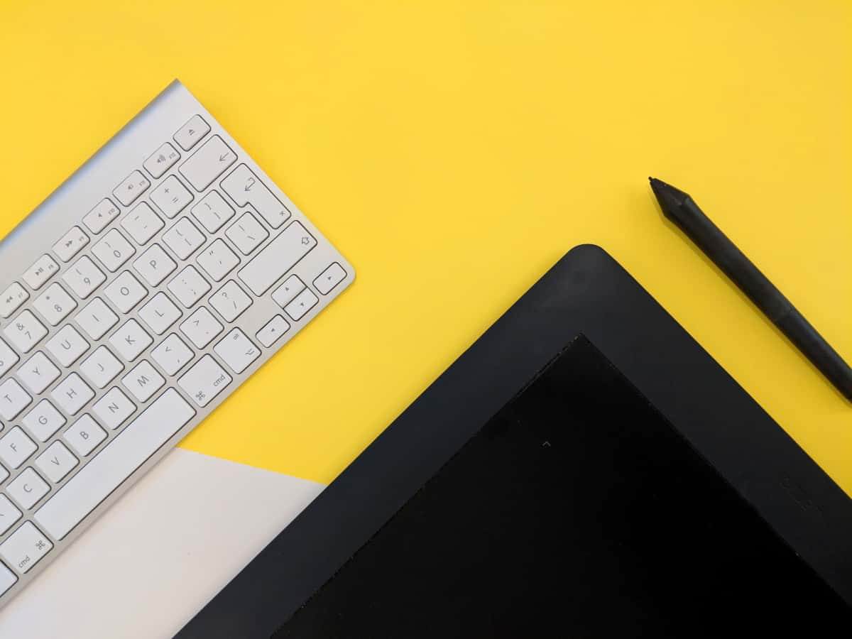 A photo of a drawing tablet and a keyboard on a bright desk.