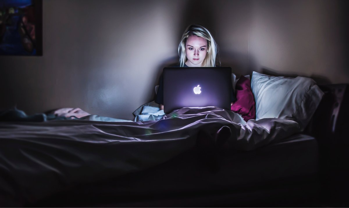  A photo of a female entrepreneur working late at night in bed.