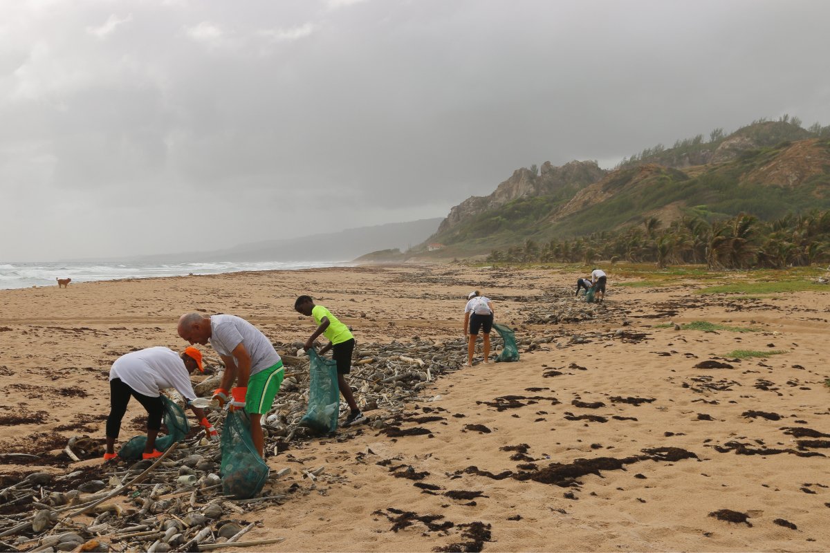 A photo of volunteers cleaning up litter on a beach.