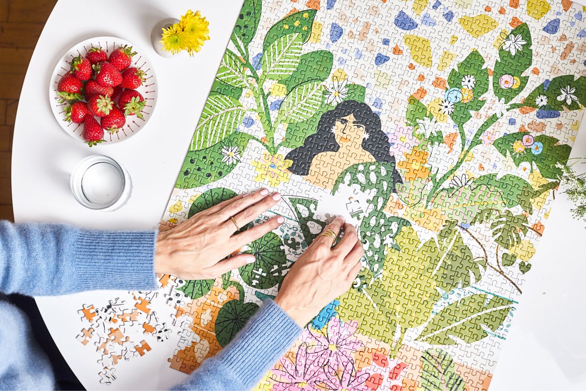 A photo of a woman putting together a JIGGY puzzle.