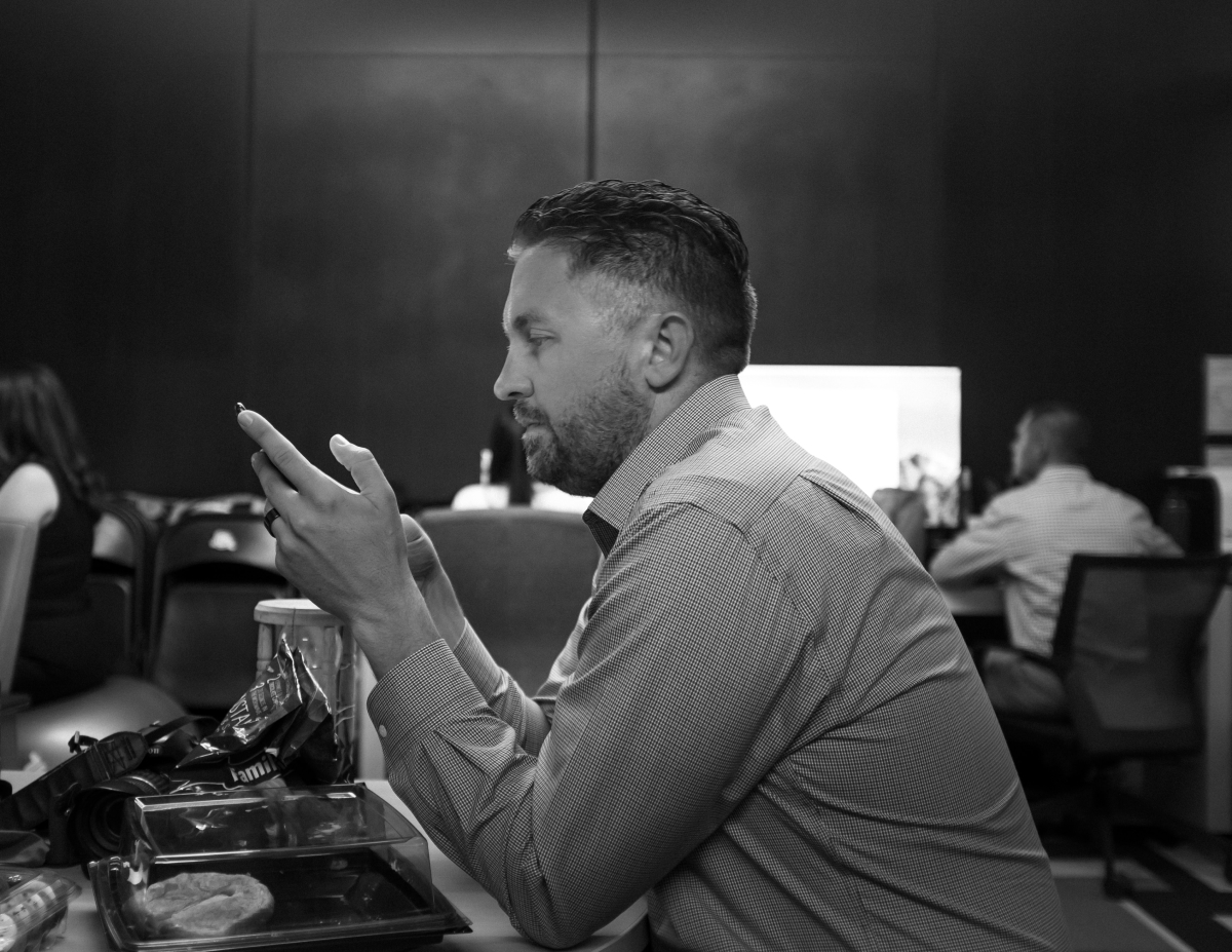 A photo of a man eating his lunch at his desk while he gets work done.