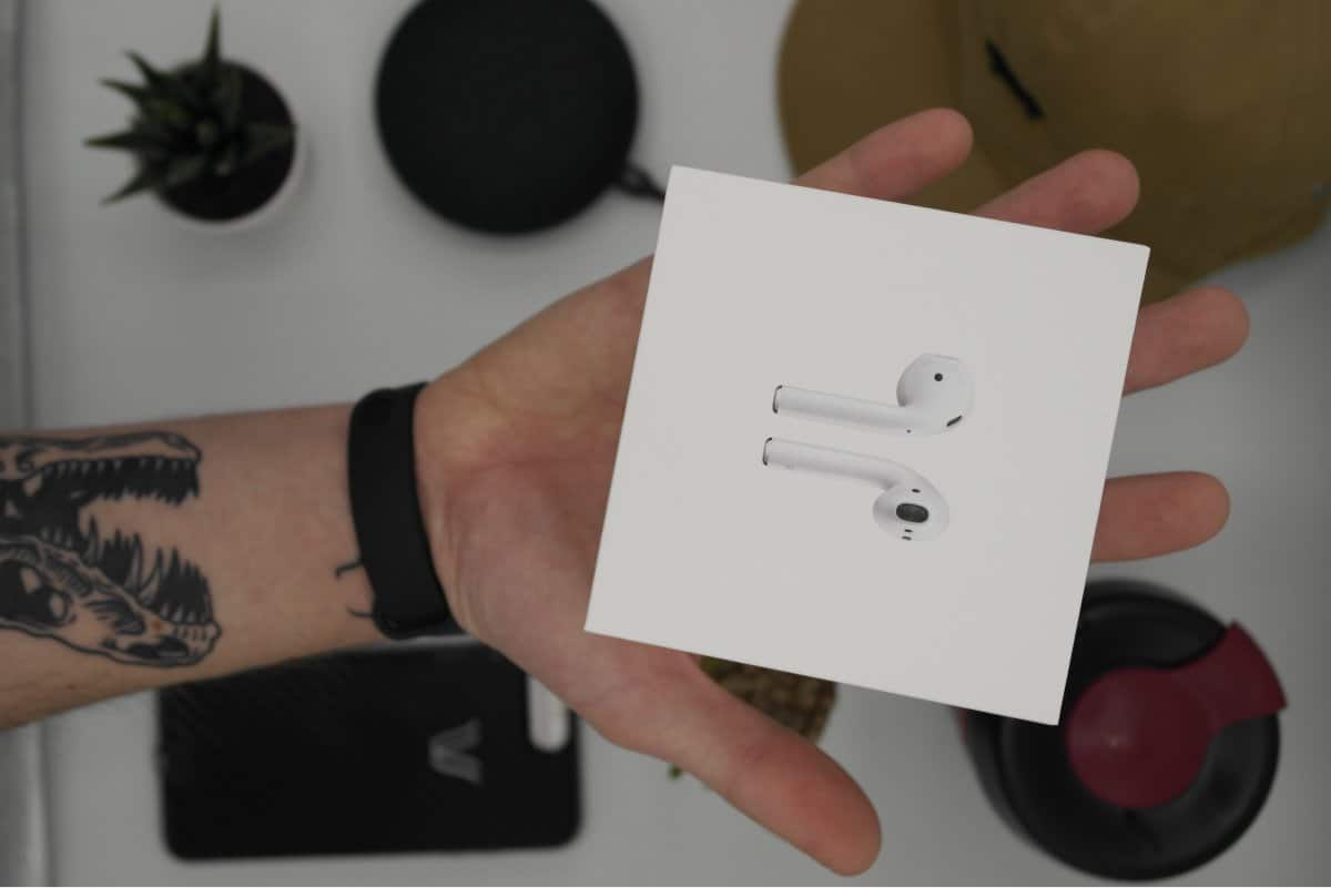 A photo of a new box of Apple AirPods in a person’s outstretched hand.