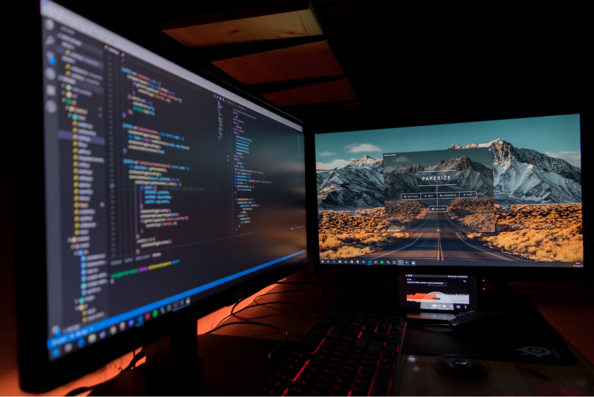 A photo of two computer monitors set up side-by-side, one of which is displaying code a developer is working on.