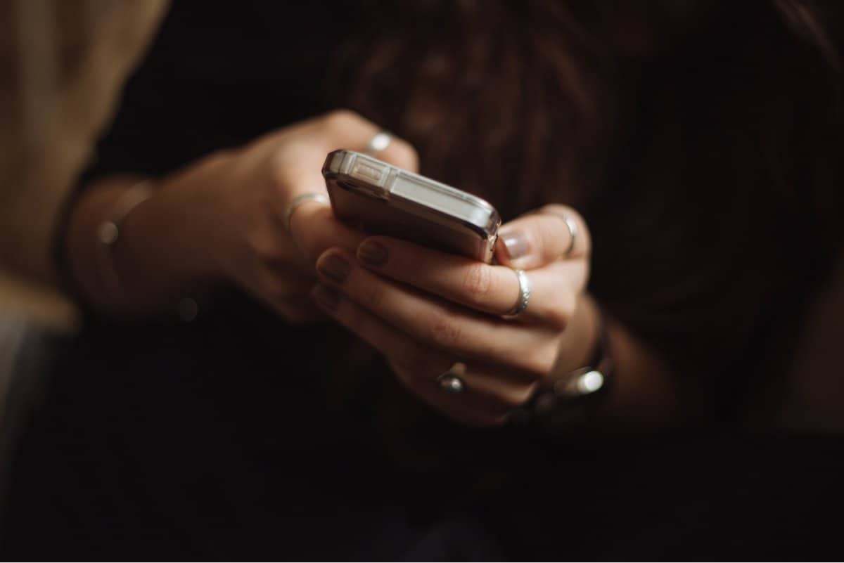 A closeup photo of a woman’s hands holding her smartphone.