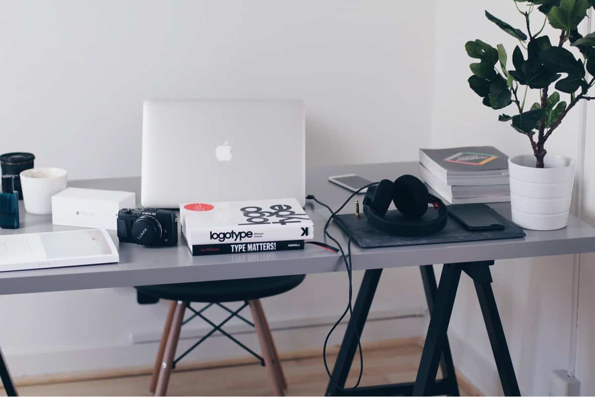 A photo of a mobile app designer’s desk, featuring a laptop, camera, and books about font face.