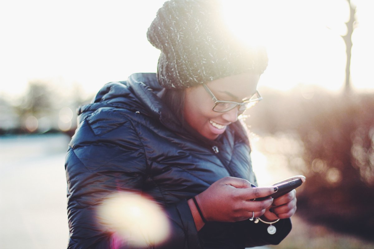 A photo of a woman playing a game on her smartphone.