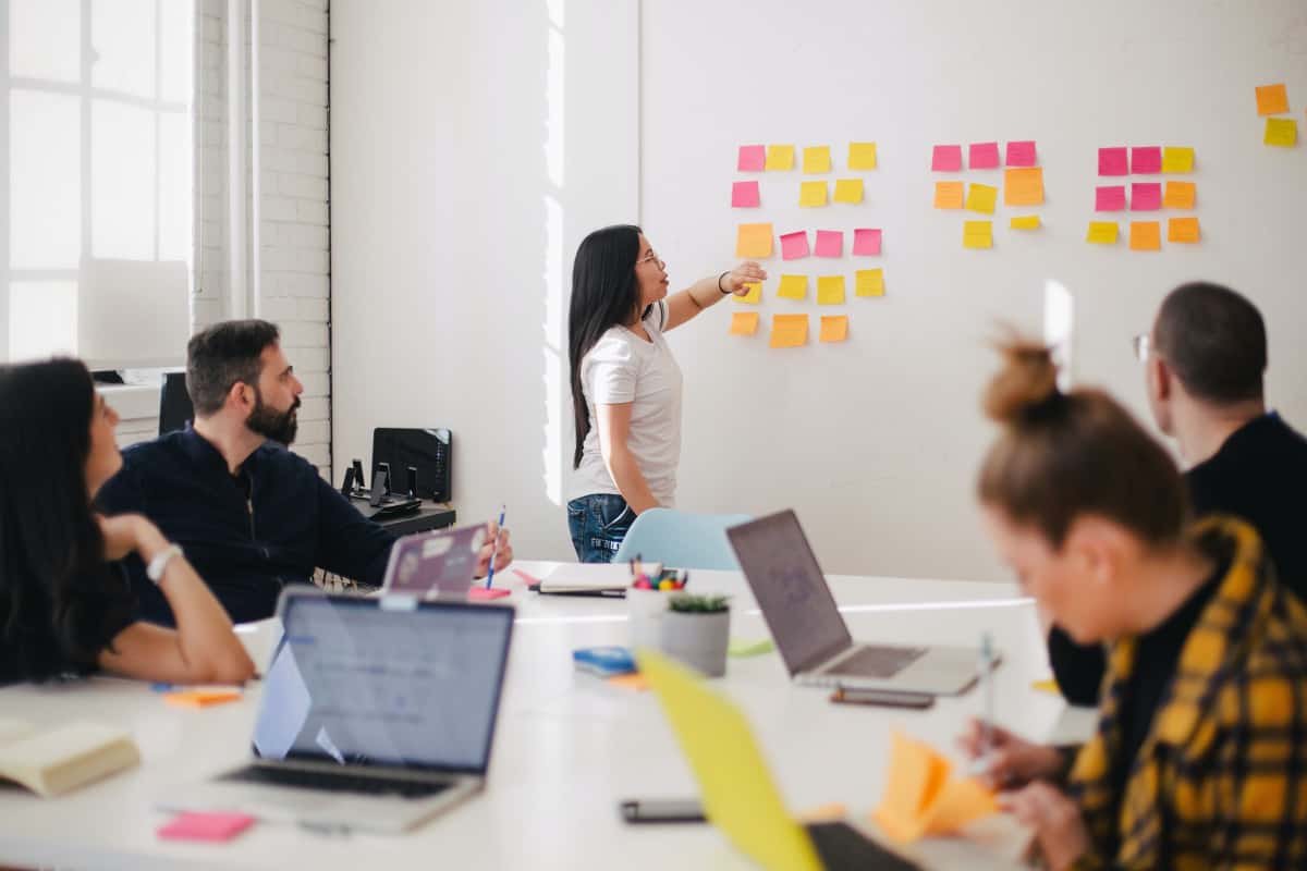 Woman with Post-It notes on a whiteboard.