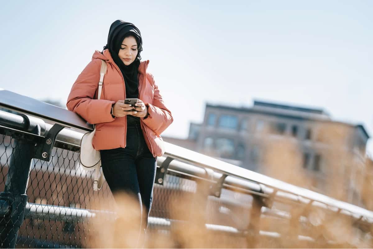 A woman researching mobile apps outside on a winter day. 